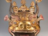 a close up of a gold mask on a gray background