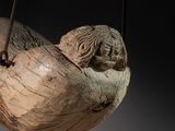 a wooden sculpture of a bird hanging from a string