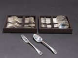 two trays of silverware with spoons and spoons on a table