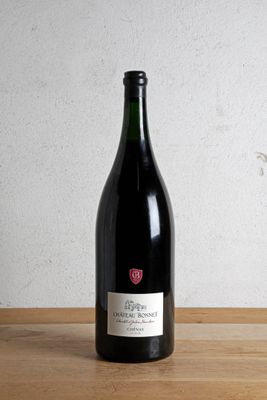 a bottle of wine sitting on a table next to a glass of wine