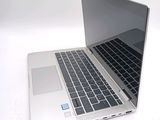 a silver laptop computer sitting on top of a white table
