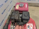 a man that is working on a lawn mower