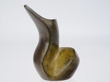 sculpture en bronze représentant un oiseau sur une surface blanche, avec un fond blanc