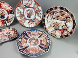 five plates with different designs are arranged on a table