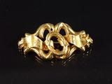 gros plan d'une bague en or sur une surface noire