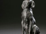 statue d'un chien assis sur un bloc de bois