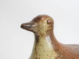 a brown and white duck statue on a white surface