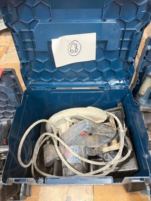 une boîte à outils bleue contenant des outils, posée par terre