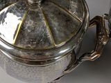 a silver pot with a lid sitting on a table
