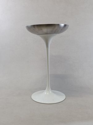 a white pedestal with a silver bowl on top of it