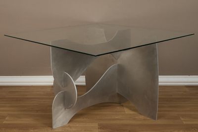 une photo d'une table en verre avec un piètement en métal