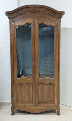 Armoire en bois clair mouluré ouvrant à deux vantaux vitrés …