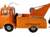 un petit camion orange muni d'une grue