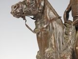 bronze statue of a man riding a horse with a helmet on