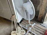 a fan that is sitting on a pallet next to a fire hydrant