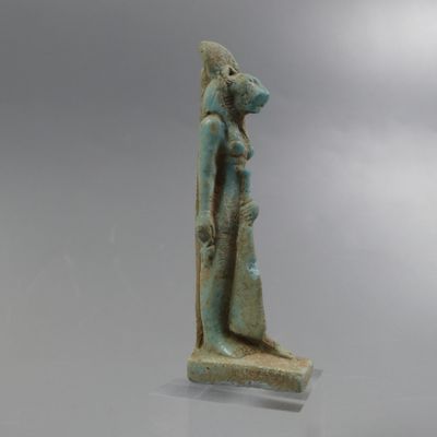une statue égyptienne antique représentant une femme tenant un enfant dans ses bras
