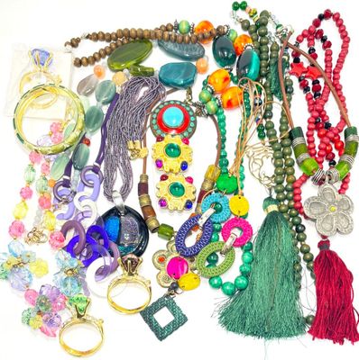 un tas de colliers et de bracelets de toutes sortes posés sur une surface blanche