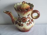 a brown and red teapot on a white table