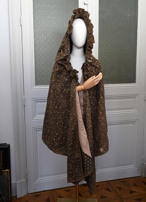 un mannequin vêtu d'un manteau marron et d'une écharpe