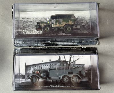 two military vehicles that are sitting in a display case