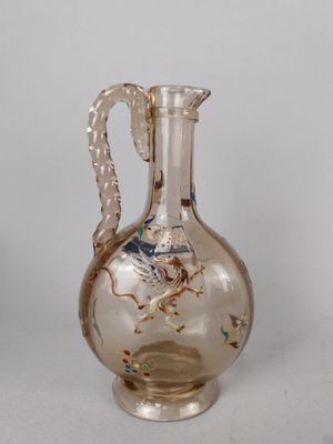 un vase en verre orné d'un dragon, posé sur une table