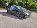 the tesla model y is parked on the side of the road