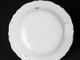 a close up of a white plate on a black surface