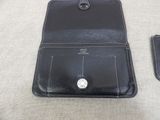 wallet and card case sitting on a couch with a cell phone next to it