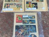 three comics are sitting on a table in front of a book