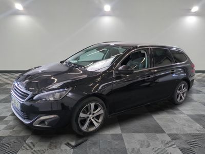 la voiture noire est garée sur un sol en damier dans le garage