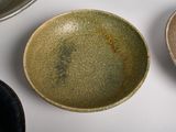 three different colored bowls sitting on a white surface