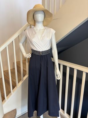 un mannequin portant une robe et un chapeau, posé sur un escalier