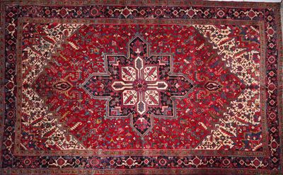 a red rug with a design on the middle of it