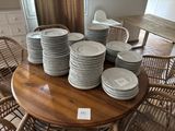 a lot of plates stacked on a table in a room