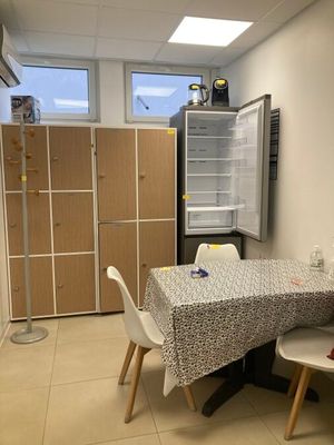 une table et des chaises dans une petite pièce équipée d'un réfrigérateur