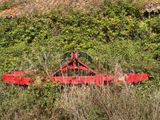 a red tractor that is sitting in the grass