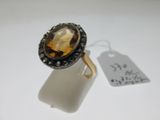 an image of a ring with a large faceted stone surrounded by black diamonds