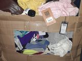 a cardboard box filled with clothes and a cell phone