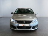 the front of a silver car in a showroom with a white wall