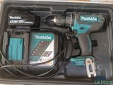 a box with a corded drill and a charger in it