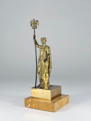 bronze statue of a woman holding a bird on a marble base