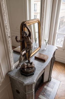 une statue représentant une femme assise sur une table dans une pièce
