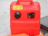 a red gas can sitting next to a pair of carrots