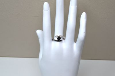 a white mannequin hand with a ring on it