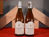 two bottles of wine sitting on a table next to each other