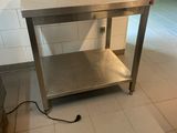 une table en acier inoxydable au milieu d'un sol carrelé