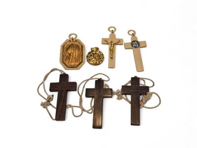 three wooden crosses and a gold medal on a white background