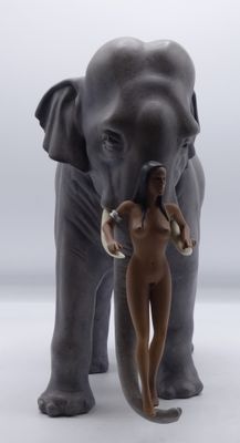a statue of an elephant and a woman standing next to each other