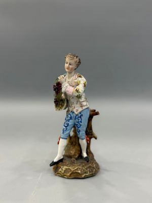 figurine représentant un homme assis sur une souche d'arbre, tenant un panier de fleurs