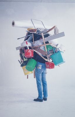 a man that is standing in the snow with a lot of stuff on his back
